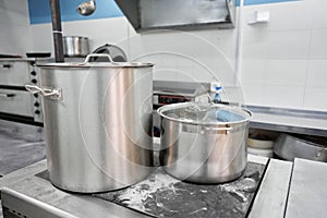 Closeup of large pots on the stove. Chef cooking at commercial kitchen - hot job. real dirty restaurant kitchen.