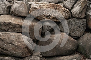 Closeup of large rocks or boulders. Large colored granites. Details of big grey stone structures with orange particles