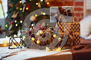 Closeup of a large stack of wrapped Christmas presents of varying sizes and shapes in Xmas interior.