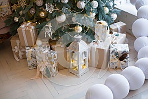 Closeup of a large stack of wrapped Christmas presents of varying sizes and shapes in Xmas interior.