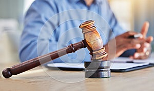 Closeup, lawyer and gavel of judge in office of trial, attention and meeting for justice in courtroom, law firm or table