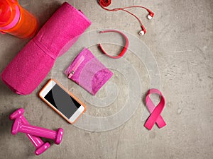 Dumbbells, towel, smartphone and pink ribbon shaped elastic band