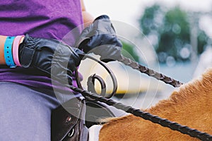 Closeup of leather gloves and reins at horse show