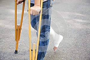 Closeup of leg on bandage with crutches