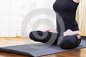 Closeup of Legs of Caucasian Brunette Woman Practicing Yoga Indoors. Doing Stretching Exercises In Physical Lotus Therapy Pose