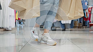 Closeup legs of shopper walking and spinning in clothing store