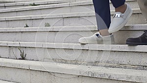 Closeup of legs walking down stairs, colleagues leaving office after workday