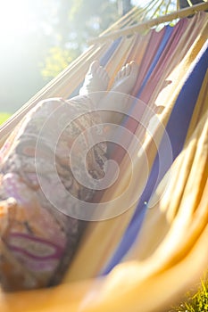 Closeup of Legs of Young Caucasian Blond Girl Relaxing In Hammock In Green Forest Outdoors