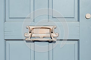 Closeup of letter box in a wooden door