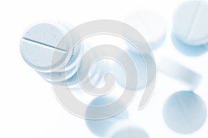 Closeup light blue pills on white background,shallow depth of field.