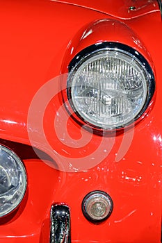 Closeup of light on red car. Beautiful modern red car headlights