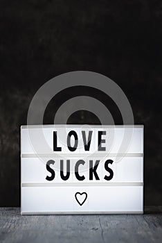 Text love sucks in a lightbox photo