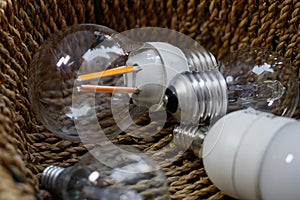 Closeup of lightbulbs in a wicker basket - recycling, energy crisis and lack of inspiration concept