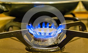 Closeup of a lighted gas cooker, burning blue flames, vintage kitchen equipment