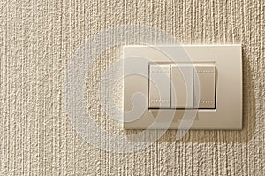 Closeup of lighting switch on concrete texture wall.