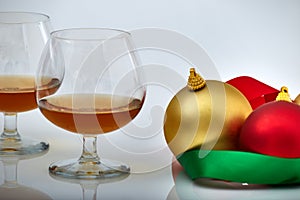 Closeup of liquor glass with Christmas ornaments, white backgrounds and reflections