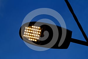 Closeup of the lit ledd lights of a street lamp on the street at dusk