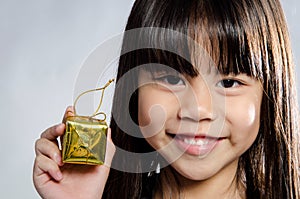 Closeup of Little asian smile girl with gold gift box