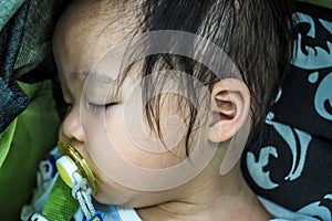 Closeup little baby girl sleeping with dummy in mouth