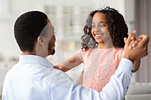 Closeup of little black girl dancing with her dad