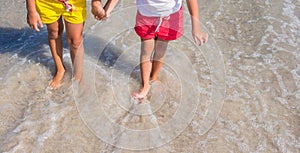 Closeup of little girls legs on tropical beach