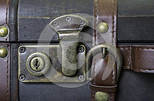 Closeup of lock and leather strap on vintage suitcase, travel co