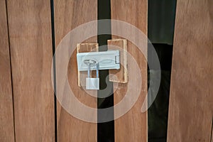 Closeup on locked padlock on wooden door