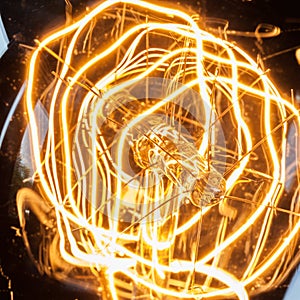 Closeup looping filament of vintage edison light bulb.