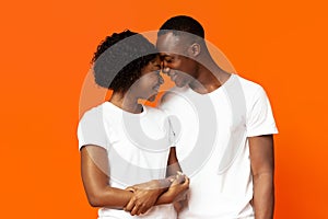 Closeup of loving black couple bonding on orange