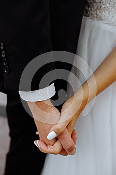 Closeup of loving couple holding hands while walking at sunset