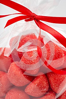 Closeup on luxury bag of candy strawberries with red ribbon