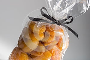 Closeup on luxury bag of dried apricots with black ribbon