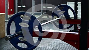 Closeup macro close up of handsome bodybuilder guy prepare to do exercises with barbell in a gym, keep barbell plate in