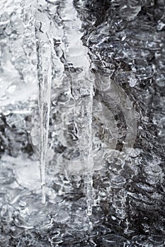 Closeup macro of melting icicles on rocks