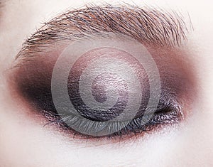 Closeup macro portrait of closed human female eye.  Girl with perfect violet - black smoky eyes make-up