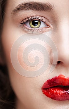 Closeup macro portrait of female face. Human woman half-face with unusual beauty makeup. Girl with perfect skin, green pistachio