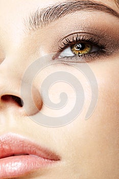 Closeup macro portrait of female face with pink lips and smoky eyes beauty makeup