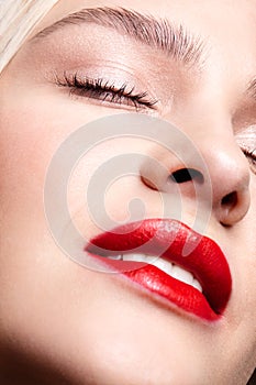 Closeup macro portrait of female face with red smiling lips and beauty makeup