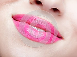 Closeup macro portrait of woman smiling lips with pink beauty makeup