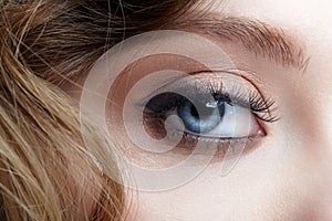 Closeup macro shot of blue human female eye. Woman with natural face beauty makeup