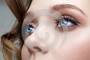 Closeup macro shot of blue human female eyes. Woman with natural face beauty makeup