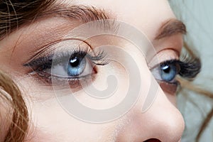 Closeup macro shot of blue human female eyes. Woman with natural face beauty makeup