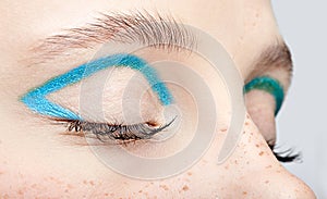 Closeup macro shot of closed human female eye and with blue smoky eyes shadow