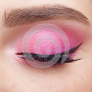 Closeup macro shot of closed human female eye. Girl with perfect skin and  pink eyes shadows