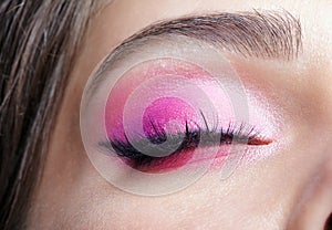 Closeup macro shot of closed human female eye. Girl with perfect skin and pink eyes shadows