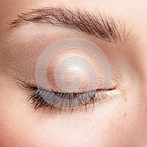Closeup macro shot of closed human female eye with natural day f