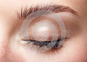 Closeup macro shot of closed human female eye with natural day f