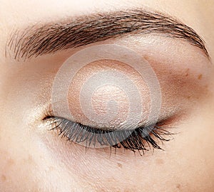 Closeup macro shot of closed human female eye with natural day f