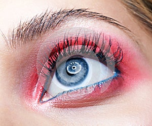 Closeup macro shot of closed human female eye with pink smoky eyes shadows