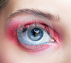 Closeup macro shot of closed human female eye with pink smoky eyes shadows